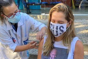 Com camiseta de Paulo Gustavo, Ingrid Guimarães toma 1ª dose de vacina da covid