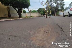 Buraco é sinalizado com galhos de árvore, enquanto erosão preocupa