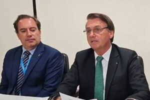 O presidente Jair Bolsonaro em live, ao lado do presidente da Caixa, Pedro Guimarães