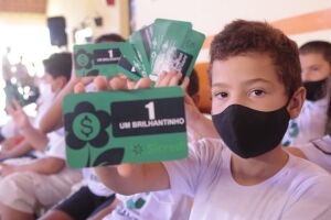 Crianças pegam alimentos saudáveis em troca de recicláveis 