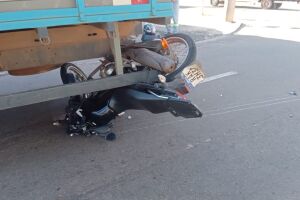 Moto ficou presa no caminhão