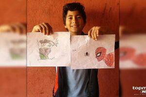 Matheus com alguns dos desenhos que faz