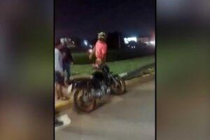 Homem em surto tentando agredir motociclista