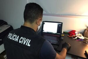 Policial faz varredura em computadores apreendidos na operação