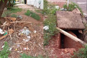 Lixo e caixa de drenagem aberta são riscos para pedestres no bairro Amambaí