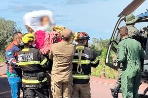 Criança sendo resgatada de helicóptero