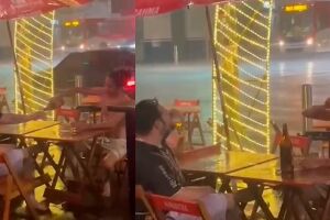 Nem a chuva segura: dupla viraliza ao tomar cervejinha em plena 14 de Julho embaixo de chuva (vídeo)