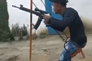 Bandido brinca de balanço enquanto segura fuzil