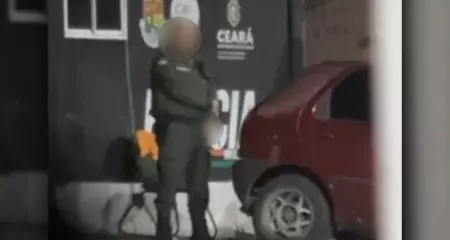 Careca e com uma farda verde, o policial &eacute; flagrado se masturbando em via &uacute;blica, em frente a uma unidade policial do bairro Pirambu