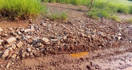 Via usada por &ocirc;nibus enfrenta desgaste, moradores usam entulhos para amenizar e comunidade pede melhorias
