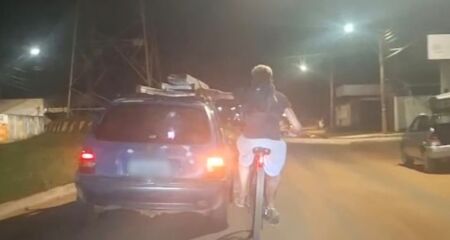 Imagens mostram que ciclista se segurava em uma escada que estava acoplada no carro