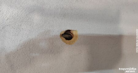  Um dos tiros atravessou a porta e atingiu o jovem nas costas