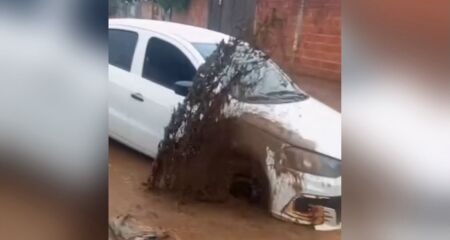 Imagens registradas por um morador mostram carro tentando sair de uma grande poça após tentar atravessar uma