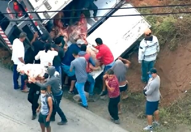 Caminhão com carne tomba e policiais levam pedradas ao tentar evitar saque