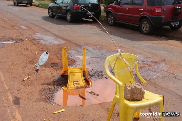 Moradores criam 'pesqueiro' em cratera no asfalto de avenida de Campo Grande