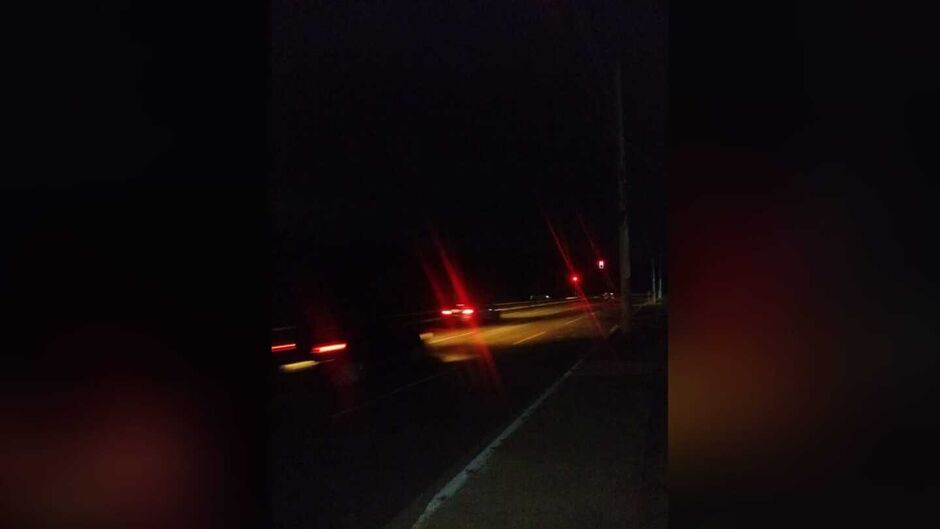 À noite, somente o farol dos carros iluminam a via