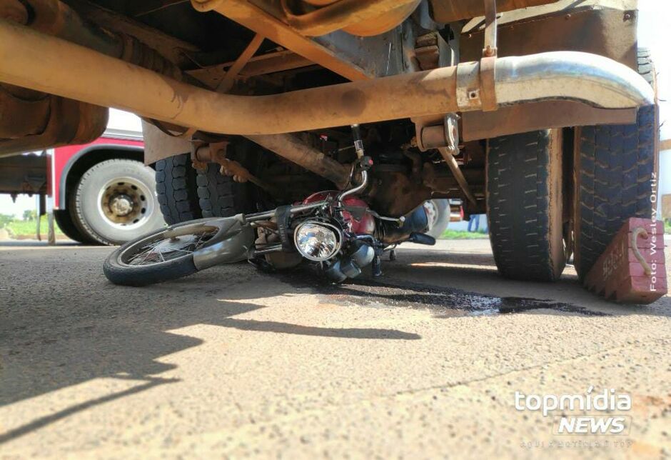 Motocicleta ficou debaixo do caminhão