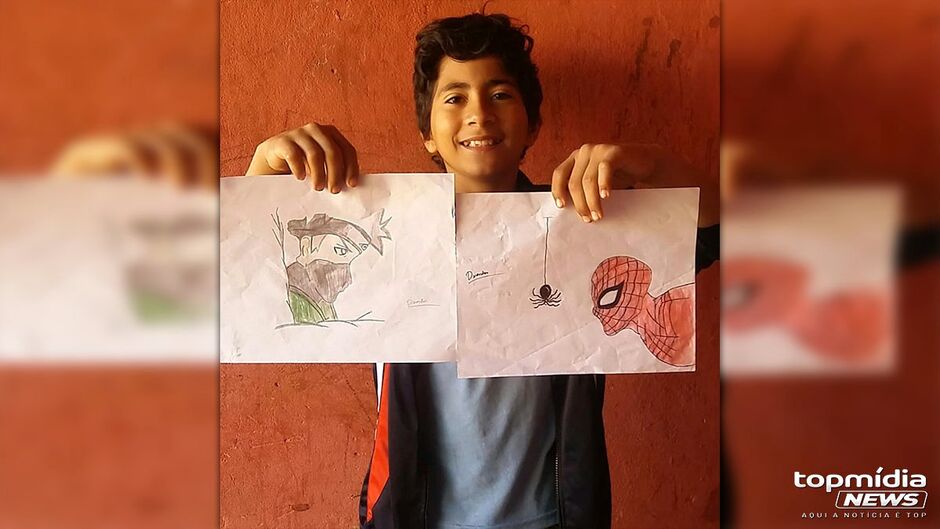 Matheus com alguns dos desenhos que faz