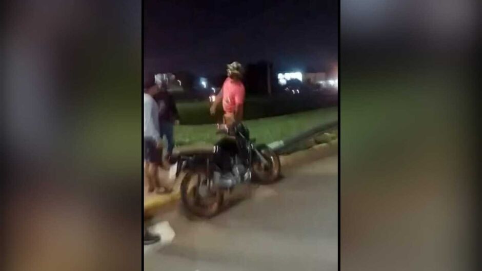 Homem em surto tentando agredir motociclista