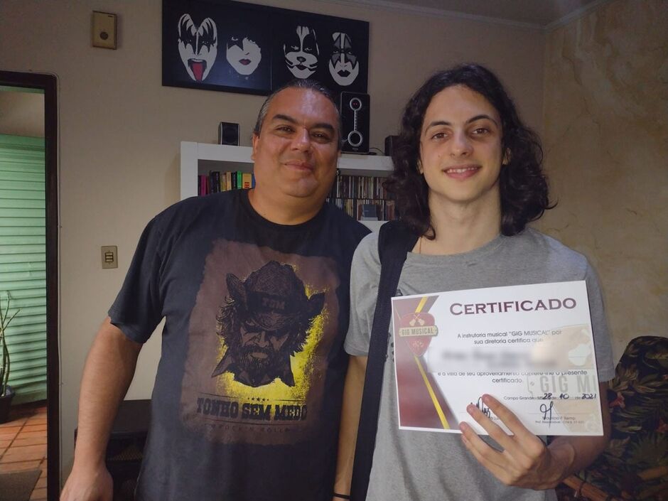 Maurício posa com aluno que concluiu o curso de guitarra