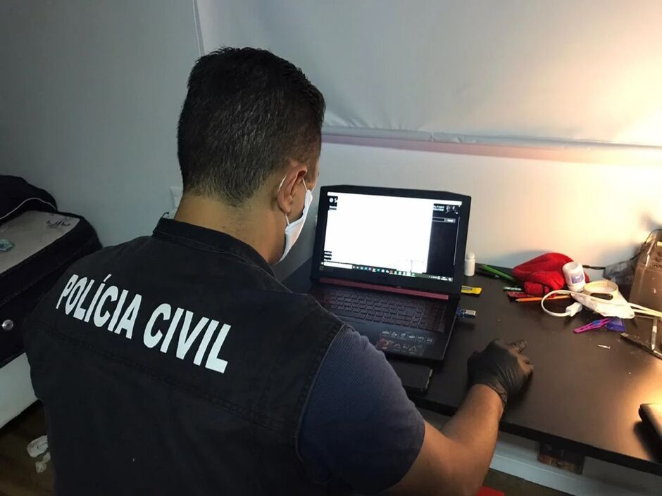 Policial faz varredura em computadores apreendidos na operação