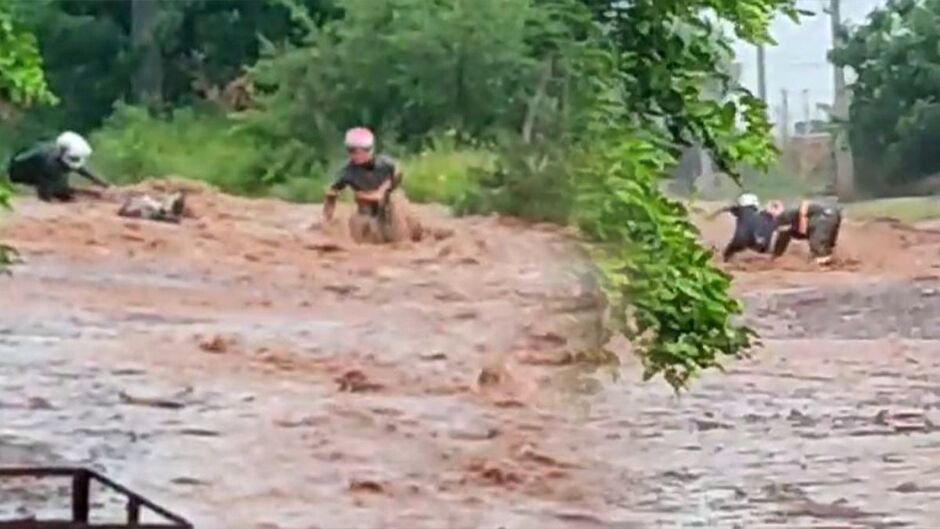 Imagens mostram momento que amigos caem e são levados pela enxurrada