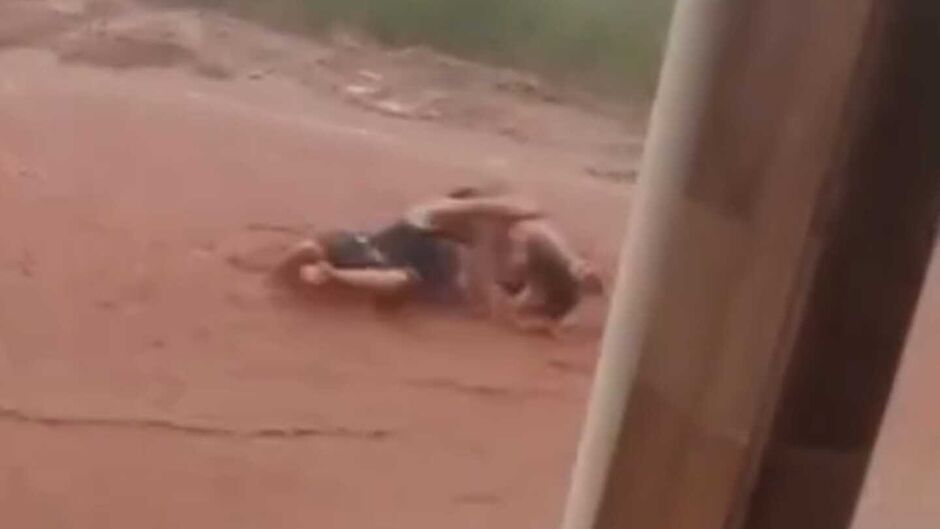 Brincadeira ou pancadaria? Homens rolam em enxurrada em rua de terra em Água Clara